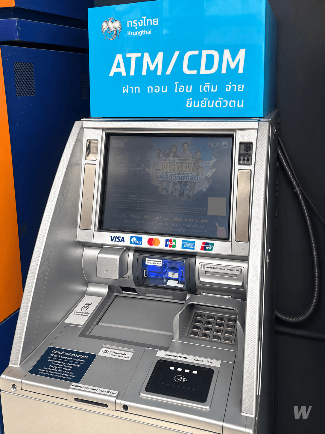 Банкомат Krungthai под голубой вывеской ATM/CDM с логотипом птицы
